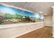 Finished basement with wood-look flooring and a scenic mural adorning the wall at 402 Clyde Ct, Mcdonough, GA 30252
