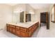 Bright bathroom featuring dual vanity sinks, wood cabinets, and tile flooring at 402 Clyde Ct, Mcdonough, GA 30252