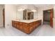 Bathroom featuring a corner dual sink vanity, tiled floor, and a glass enclosed shower at 402 Clyde Ct, Mcdonough, GA 30252