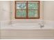 Bright bathroom featuring a tiled soaking tub with a wooden window view at 402 Clyde Ct, Mcdonough, GA 30252