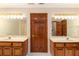 Well-lit bathroom featuring dual vanities and a door to the toilet room for added convenience at 402 Clyde Ct, Mcdonough, GA 30252
