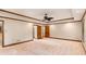 Expansive carpeted bedroom featuring wood trim, a ceiling fan, and multiple doorways at 402 Clyde Ct, Mcdonough, GA 30252