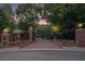 Gated entrance to a brick home with beautiful flowers and greenery leading to a large brick home at 402 Clyde Ct, Mcdonough, GA 30252