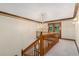 A carpeted hallway has wood trim and a chandelier hangs above the top of the staircase at 402 Clyde Ct, Mcdonough, GA 30252