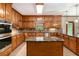 Modern kitchen featuring a kitchen island, hardwood cabinets, stainless appliances, and hardwood floors at 402 Clyde Ct, Mcdonough, GA 30252