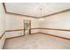 Spacious living room featuring carpet flooring, wood trim, and chandelier lighting at 402 Clyde Ct, Mcdonough, GA 30252