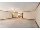 Large living room with carpet that leads to a hallway with a staircase and lighting fixture at 402 Clyde Ct, Mcdonough, GA 30252