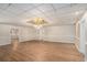 Expansive living room with hardwood floors, featuring neutral walls, bright light fixture, and multiple entryways at 402 Clyde Ct, Mcdonough, GA 30252
