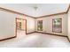 Bright living room featuring neutral walls, white carpet, and wood trim at 402 Clyde Ct, Mcdonough, GA 30252