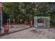 Charming outdoor seating area with white swing, brick accents, and views of the surrounding wooded landscape at 402 Clyde Ct, Mcdonough, GA 30252