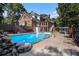 Backyard pool and home exterior featuring a brick facade and lush landscaping at 402 Clyde Ct, Mcdonough, GA 30252