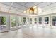 Large sunroom with tile floor and several windows offering views of wooded backyard at 402 Clyde Ct, Mcdonough, GA 30252