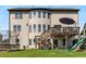 Expansive backyard featuring a two-story home with a deck, patio, trampoline, playground, and lush green lawn at 5240 Bristlecone Pine Way, Cumming, GA 30040