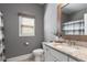 A bathroom featuring a white vanity with granite countertop, toilet and a window with wood trim at 5240 Bristlecone Pine Way, Cumming, GA 30040