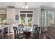 A cozy dining area features a glass-topped table, natural light and backyard views through a set of french doors at 5240 Bristlecone Pine Way, Cumming, GA 30040