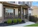 Inviting front porch with stone accents, decorative shrubs and charming railings and supports at 5240 Bristlecone Pine Way, Cumming, GA 30040