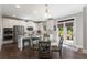 Modern kitchen featuring stainless steel appliances, a center island, and a glass breakfast table at 5240 Bristlecone Pine Way, Cumming, GA 30040