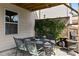Inviting covered patio with elegant outdoor dining set, lush greenery, and a grill, perfect for entertaining at 5240 Bristlecone Pine Way, Cumming, GA 30040