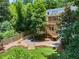 Beautiful two-story home featuring a backyard with luscious green landscaping, wood stairs and deck at 582 Lakeshore Ne Dr, Atlanta, GA 30307