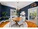 Navy dining room featuring a round table, white chairs, hardwood floors and view into kitchen at 582 Lakeshore Ne Dr, Atlanta, GA 30307