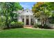 Charming white home featuring stately columns, a swing, and mature trees with a lush green lawn at 582 Lakeshore Ne Dr, Atlanta, GA 30307