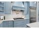 Elegant kitchen with blue cabinets, marble backsplash, and high-end appliances, including a pot filler at 582 Lakeshore Ne Dr, Atlanta, GA 30307