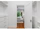 Walk-in closet leading to bedroom with hardwood floors, and custom shelving for storage at 582 Lakeshore Ne Dr, Atlanta, GA 30307