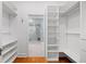 Walk-in closet leading to main bathroom with custom shelving, hardwood floors for storage at 582 Lakeshore Ne Dr, Atlanta, GA 30307