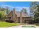 Large backyard featuring a beautiful swimming pool, wooden deck, stone retaining wall and covered patio at 6255 Hedgestone Way, Douglasville, GA 30135