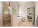 Bright bathroom featuring a walk-in shower, tub, and large windows for natural light at 6255 Hedgestone Way, Douglasville, GA 30135