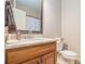 Bathroom with a wood vanity, toilet, and a framed mirror at 6255 Hedgestone Way, Douglasville, GA 30135