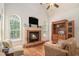 Cozy living room with a brick fireplace, hardwood floors, and large windows with backyard views at 6255 Hedgestone Way, Douglasville, GA 30135