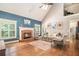 Light-filled living room with a brick fireplace, hardwood floors, and vaulted ceiling with view of upper level at 6255 Hedgestone Way, Douglasville, GA 30135