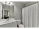 Bathroom with a white vanity, toilet, shower with white curtain, and a mirror, offering a clean and functional space at 1777 Water Springs Way, Dacula, GA 30019
