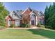 Beautiful two-story brick home with mature trees, manicured lawn, and classic architectural details at 1777 Water Springs Way, Dacula, GA 30019