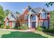 Charming two-story red brick home featuring an arched entryway and professionally landscaped front yard at 1777 Water Springs Way, Dacula, GA 30019