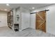 Open interior with a wooden sliding barn door, shelving, and gray vinyl flooring at 1777 Water Springs Way, Dacula, GA 30019