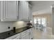 Open kitchen with granite countertops, white cabinets, backsplash, and an adjacent dining area with a table and chairs at 1777 Water Springs Way, Dacula, GA 30019