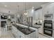Open concept kitchen with stainless steel appliances, granite countertops, and an island with seating and modern light fixtures at 1777 Water Springs Way, Dacula, GA 30019