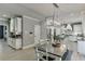 Bright kitchen features a large island, stainless steel appliances, custom white cabinets, and a dining table with bench seating at 1777 Water Springs Way, Dacula, GA 30019