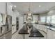Spacious kitchen with stainless steel appliances, black countertops, white cabinetry, and a large island with bar seating at 1777 Water Springs Way, Dacula, GA 30019