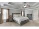 Comfortable main bedroom featuring a tray ceiling, a ceiling fan, and two windows at 1777 Water Springs Way, Dacula, GA 30019