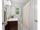 Well-lit bathroom with a dark wood vanity, neutral paint, and a window with privacy curtains at 2416 Elmwood Se Cir, Atlanta, GA 30339