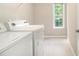 Bright laundry room with washer, dryer, and window at 3710 Ridgefair Dr, Cumming, GA 30040