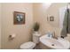 Well-lit powder room featuring pedestal sink, decorative wall art and towel bar at 510 Independence Way, Roswell, GA 30075
