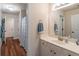 Bright bathroom featuring a white vanity, large mirror, and wood-look floors at 510 Independence Way, Roswell, GA 30075