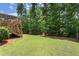 Expansive backyard with lush green lawn, mature trees, and stairs leading to an elevated deck at 5605 Miners Rdg, Cumming, GA 30028