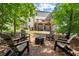 View of the backyard with a fire pit area, wooden deck, and lush tree surroundings at 5605 Miners Rdg, Cumming, GA 30028
