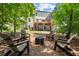 Landscaped backyard featuring a fire pit, Adirondack chairs, and an elevated deck at 5605 Miners Rdg, Cumming, GA 30028
