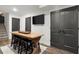 Finished basement with wooden table with stools, a flat screen TV, and double doors at 5605 Miners Rdg, Cumming, GA 30028